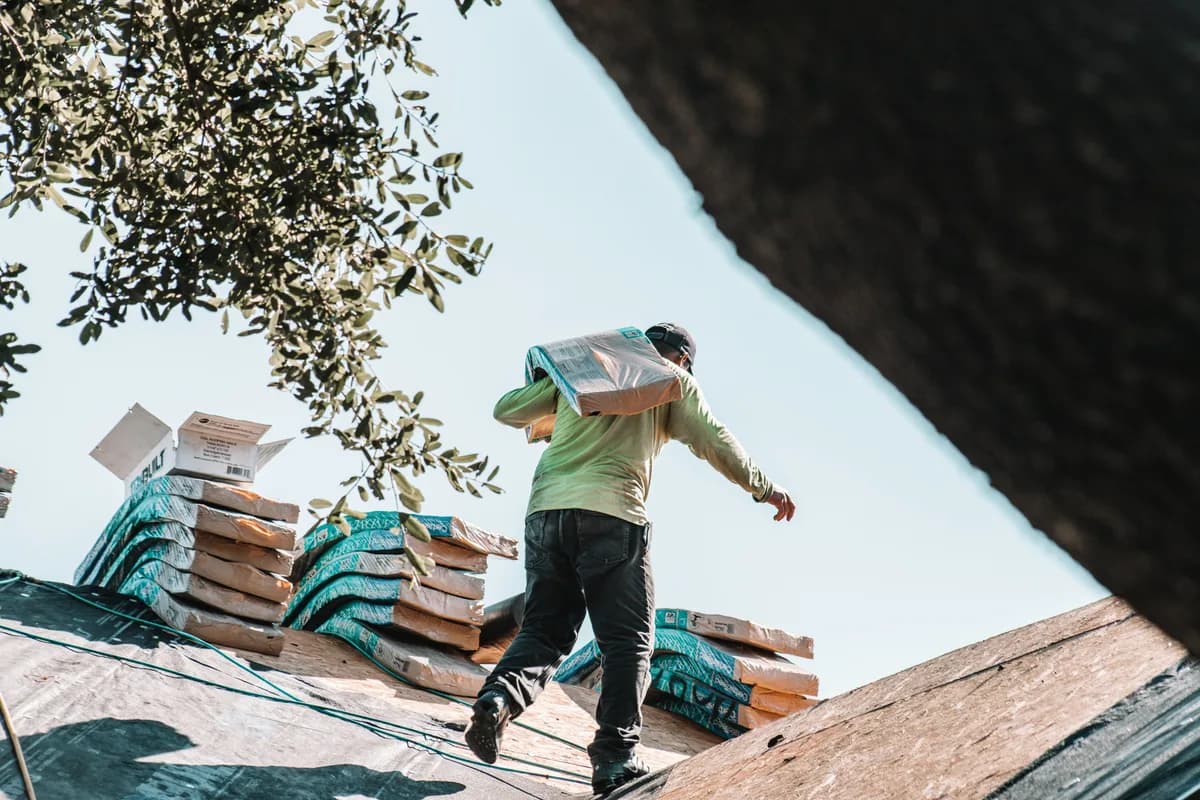 Roofer working on a pitched roof under a bright sky on a UK residential property
